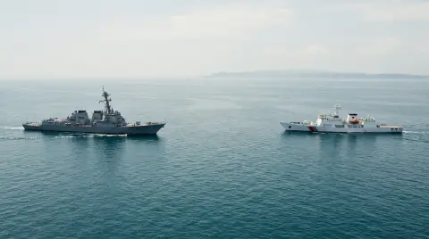 A grey destroyer and a white coast guard ship on open water, Cinematic real look