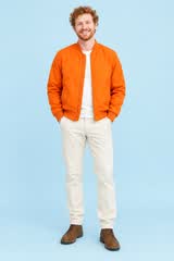 Kai, a man with ginger curls and an orange bomber jacket